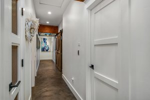 Hallway to the bedrooms has polished  concrete flooring, custom skylight with lighting