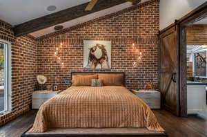 Owners suite - custom barn door divides the bedroom from the bathroom