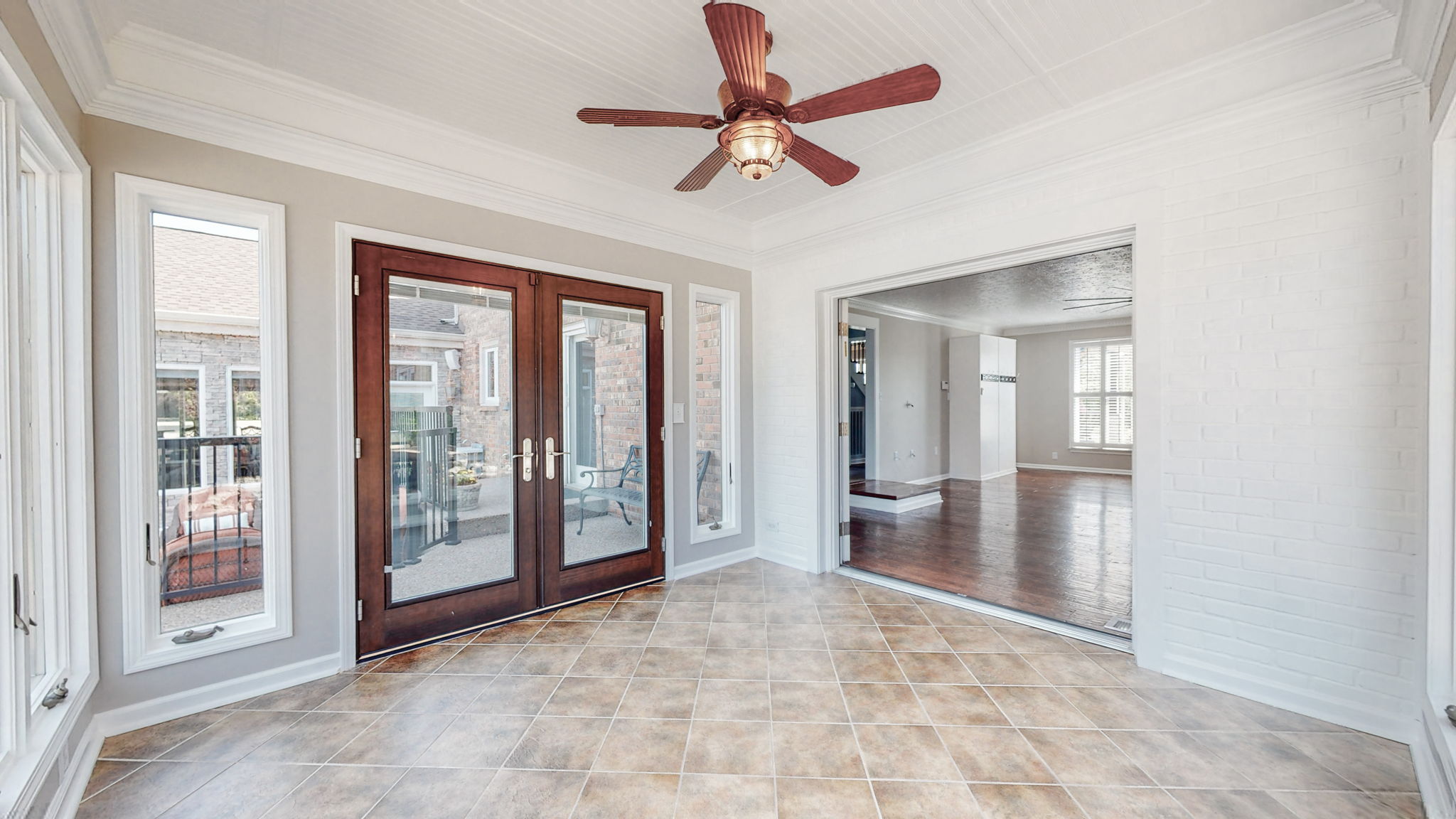 Double doors lead out to the amazing backyard from this sunroom.