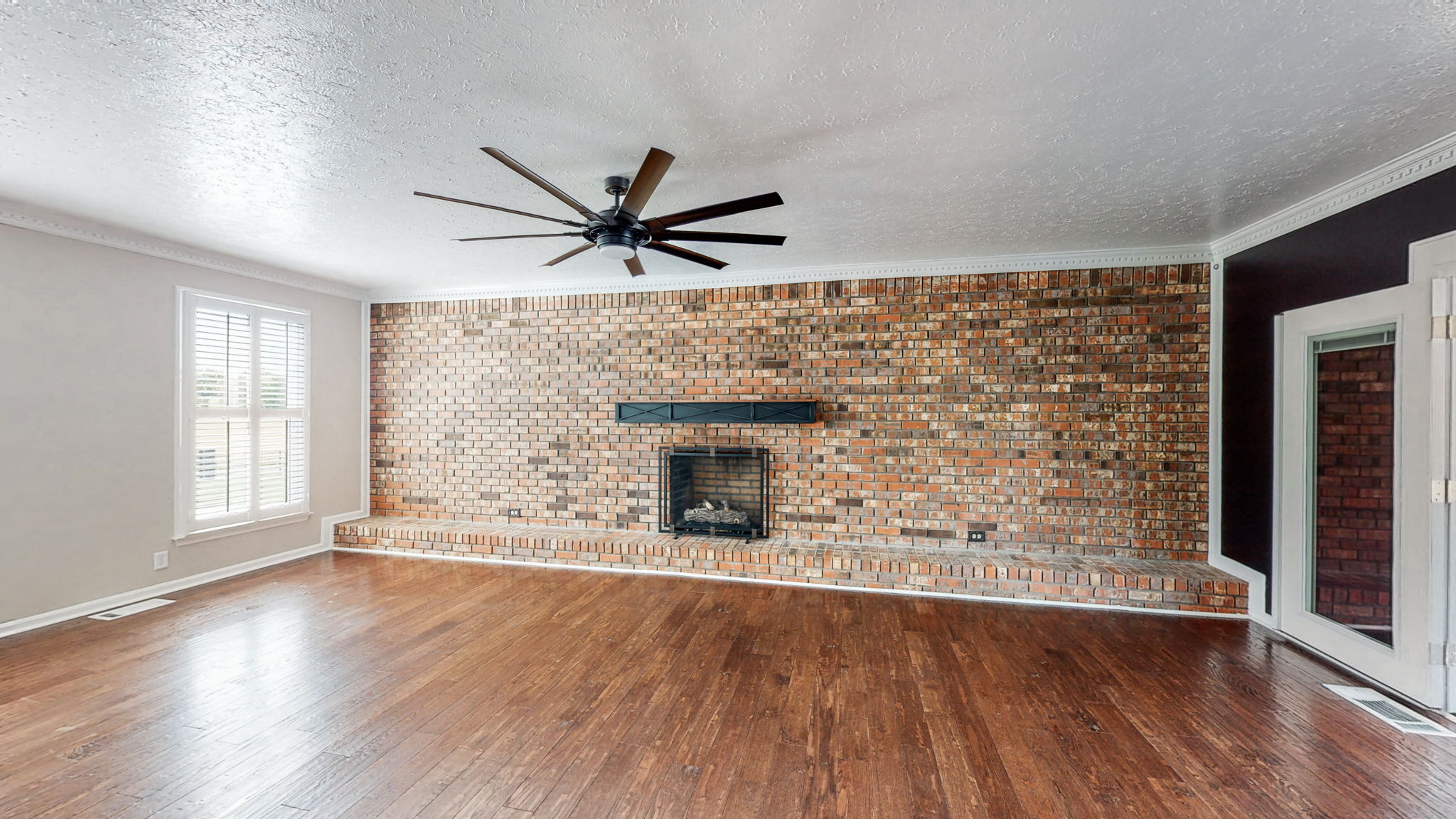 Oh the possibilities!!! This extra large room with a lovely brick wall and fireplace, wood floors and a ceiling fan could serve as an amazingly large dining room, an incredible office space or even a yoga/workout room.