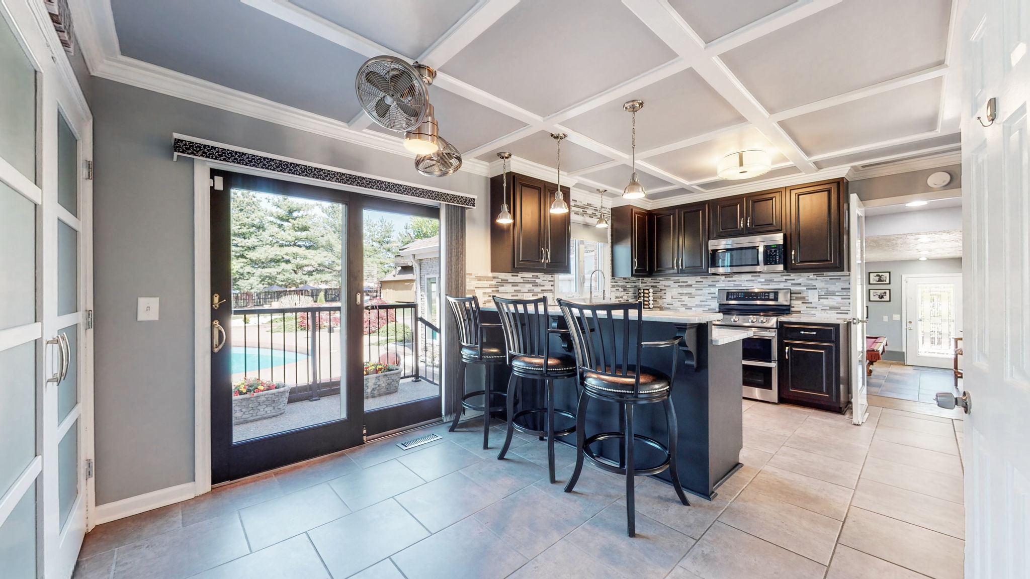 Inviting, open and spacious areas for guests to hangout with the cook.  Access to the sparkling saltwater pool from seating at the kitchen counter.
