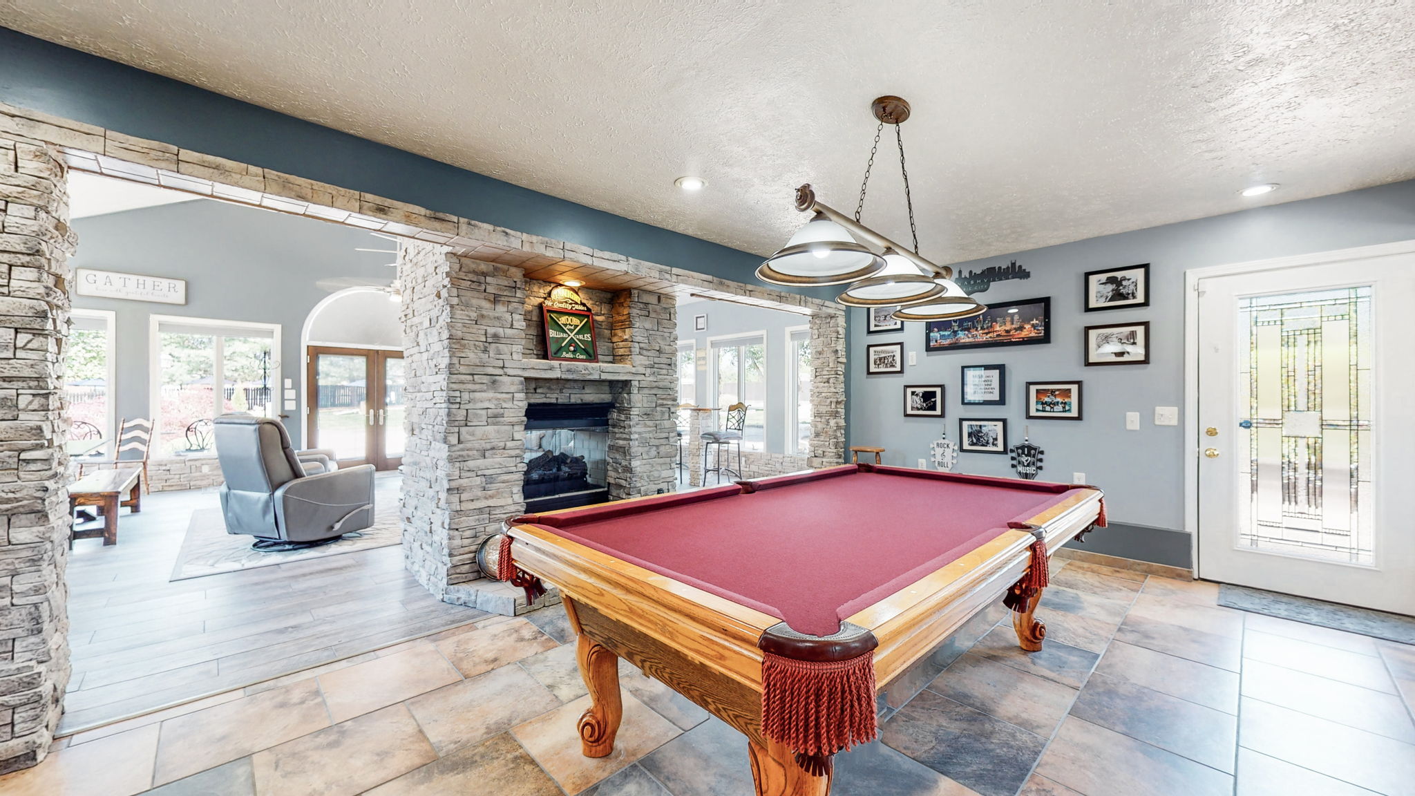 Enjoy your own pool room.  The see-through propane rock fireplace continues in this large room with beautiful tile flooring.