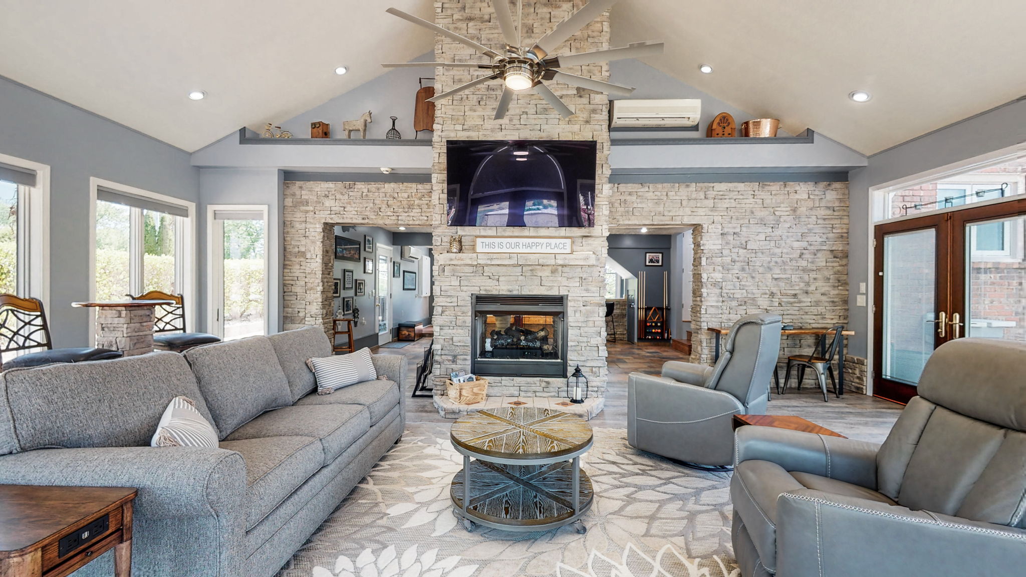 This large family sunroom displays an incredible view of the saltwater pool and beautiful professionally landscaped backyard.  It features a see-through propane rock fireplace.