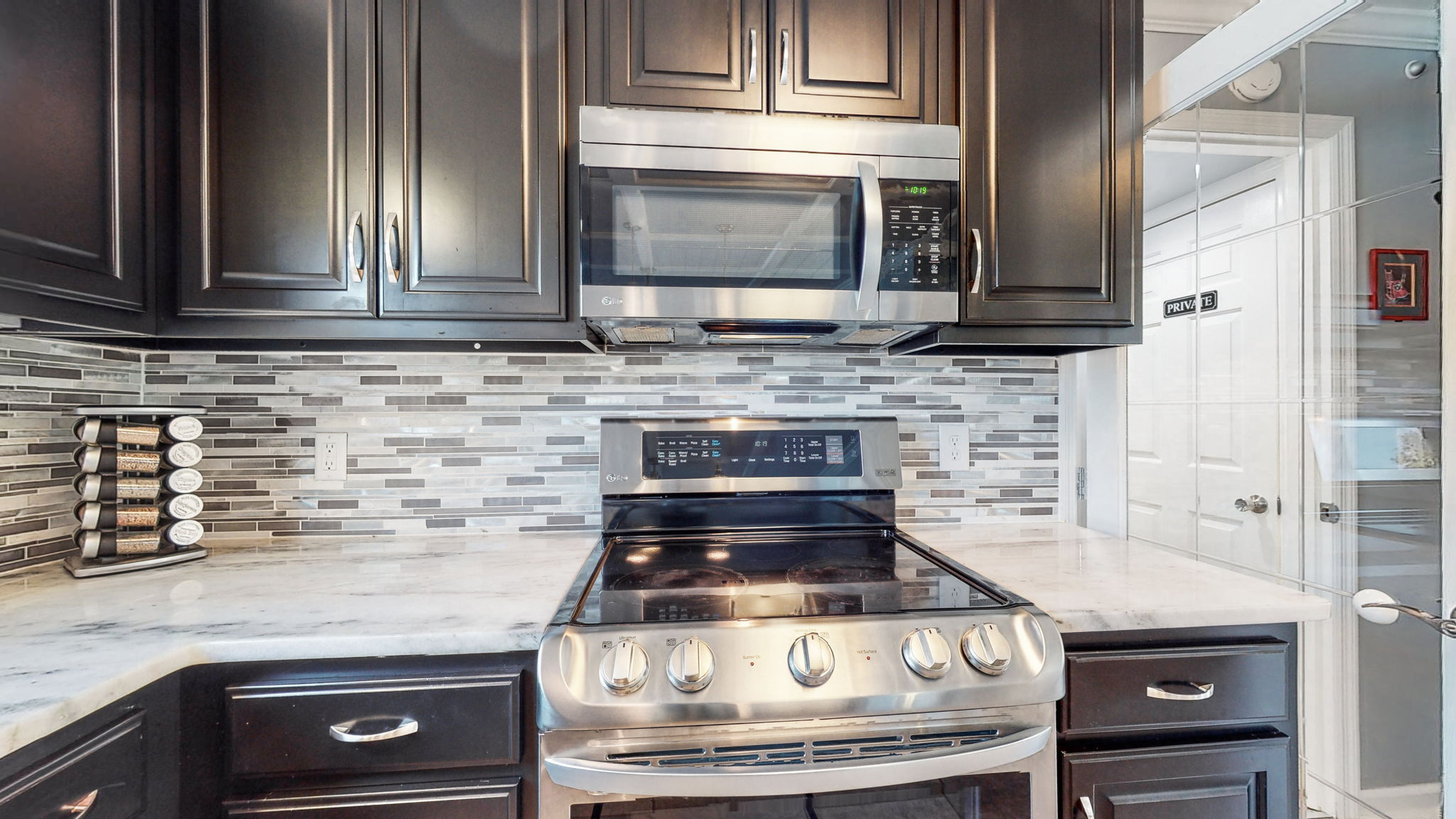 A closer look at those white marble countertops with the coordinating backsplash against the dark wood cabinets.  Lovely!