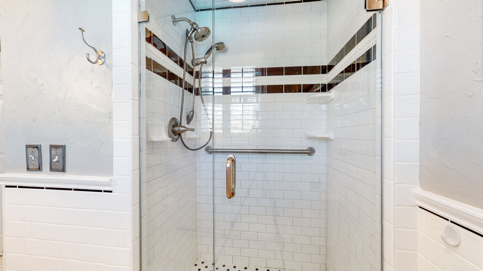 A timeless black-and-white subway tile adorn the large shower of your master bath.