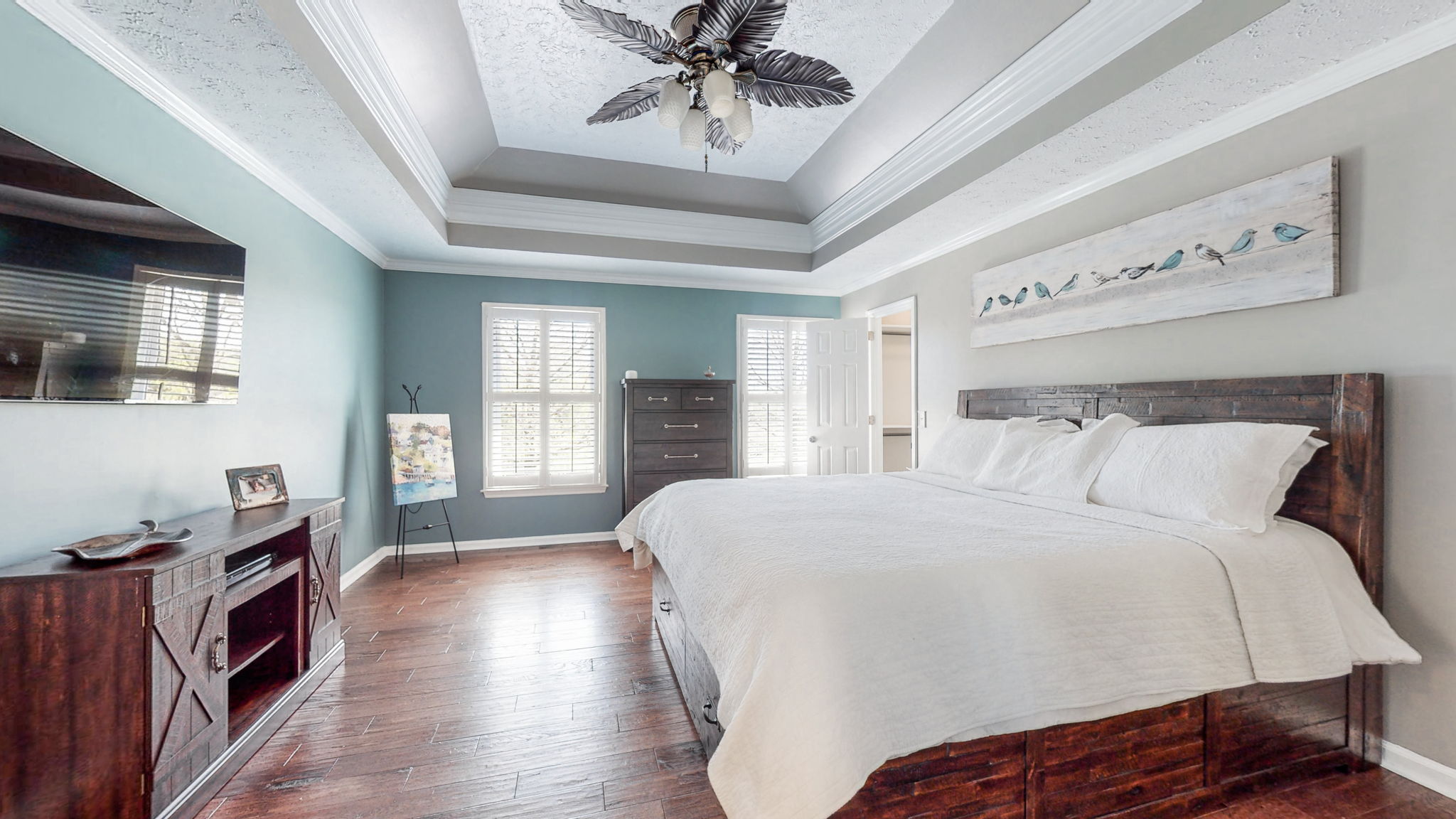 In addition to the beautiful tray ceilings and wood floors, this magnificent master bedroom has two walk-in closets and an abundance of natural light.