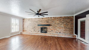 Oh the possibilities!!! This extra large room with a lovely brick wall and fireplace, wood floors and a ceiling fan could serve as an amazingly large dining room, an incredible office space or even a yoga/workout room.