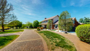 Professional landscaping invite you and your guests to this desirable property.  Once again, you can see the beautiful colored, stamped concrete circular driveway.