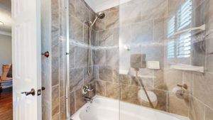 An inviting tub and shower combo decorate the second bath.