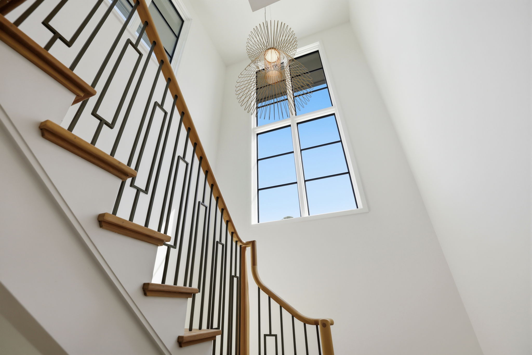 Architectural staircase with Visual Comfort Statement light fixture