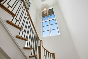 Architectural staircase with Visual Comfort Statement light fixture