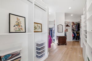 A beautifully appointed and custom walk-in closet offering dedicated his-and-hers spaces