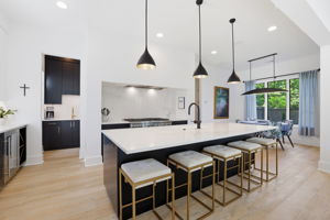 Chef-caliber kitchen anchored with spacious island featuring quartz countertops
