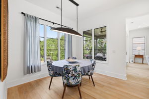 Charming dining area with serene outdoor views, highlighted by statement designer lighting