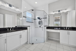 Seamless shower door, floor to ceiling tile and corner seat in shower, upgraded lighting, too! Vanity area and dual sinks. Grab bar present in shower. Lots of storage!