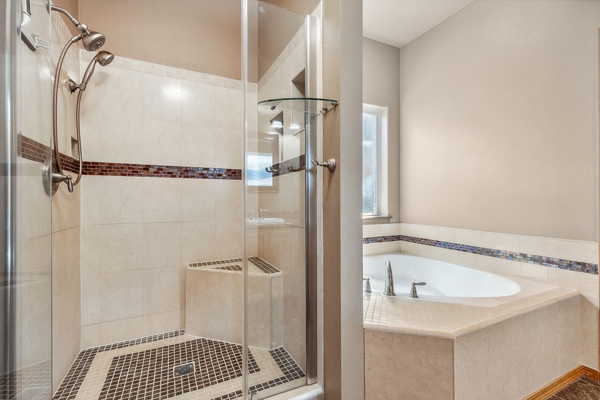 Updated shower is spacious with a corner seat.