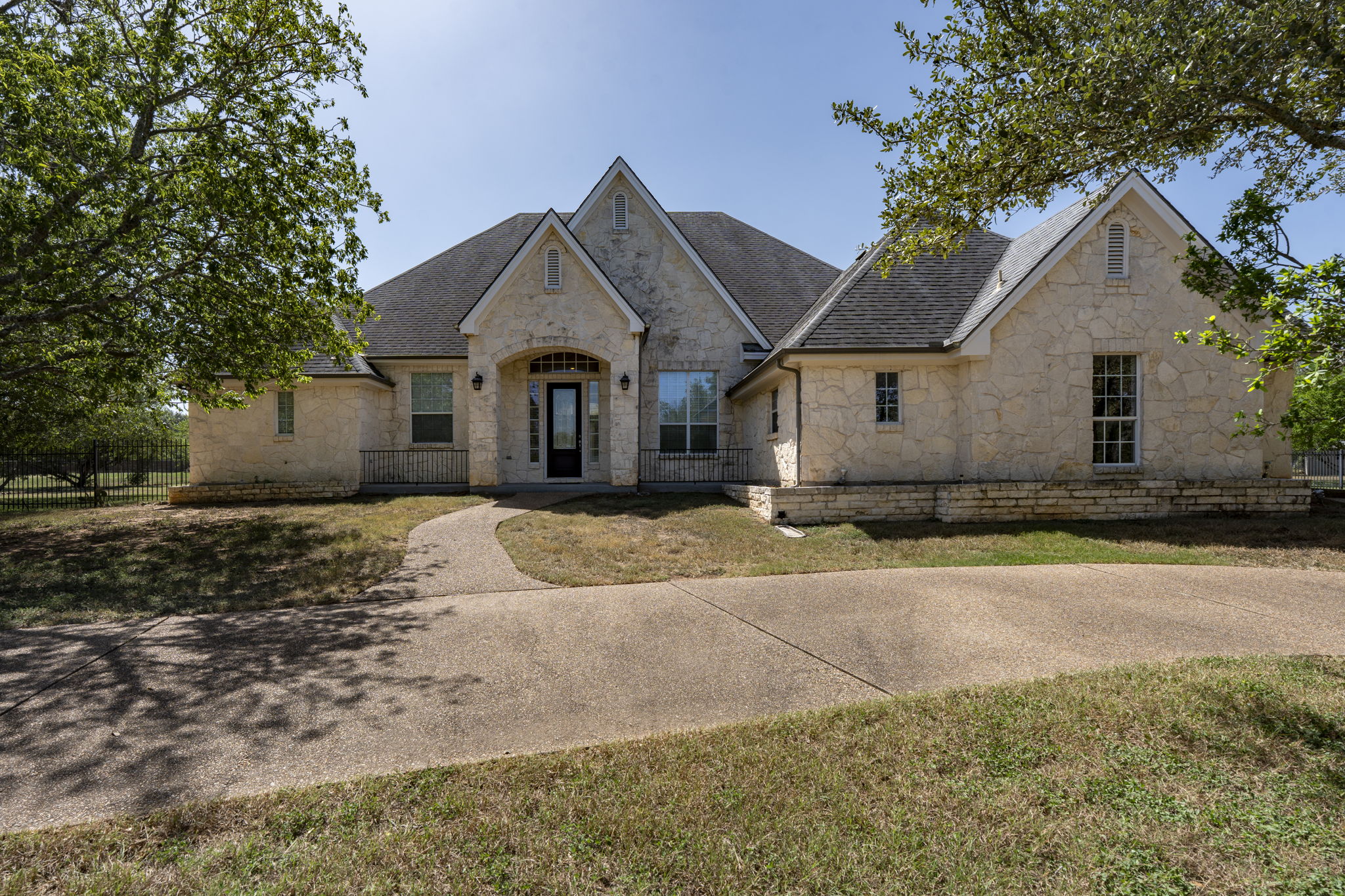 Texas stone exterior with roof line peaks elevates this homes curb appeal.