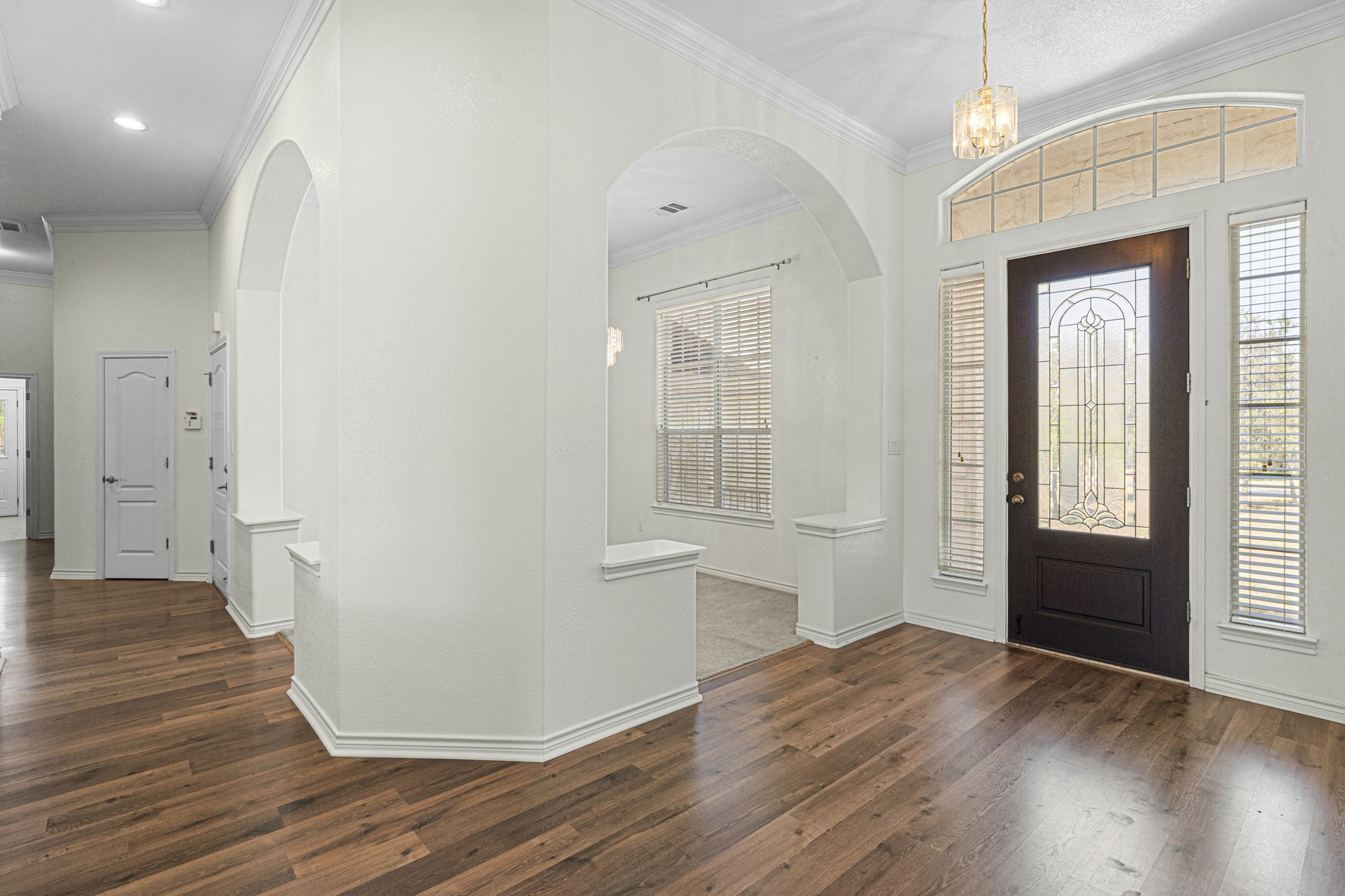 The inviting entry foyer features wood-like flooring & opens up to the formal dining.