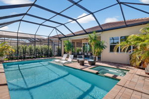 This pool area has it ALL! A heated, saltwater pool w/ sun shelf, attached hot tub, lush privacy landscaping, views of the lake and butterfly garden, and a shaded seating area off great room!