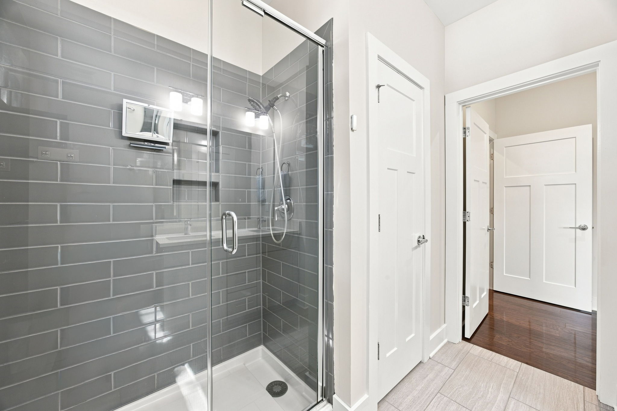 Primary Bathroom’s Spacious Glass-Enclosed Tiled Shower