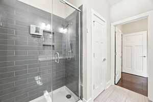 Primary Bathroom’s Spacious Glass-Enclosed Tiled Shower