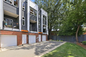 Rear Exterior with Garage Access and Adjacent Mostly Fenced Lawn