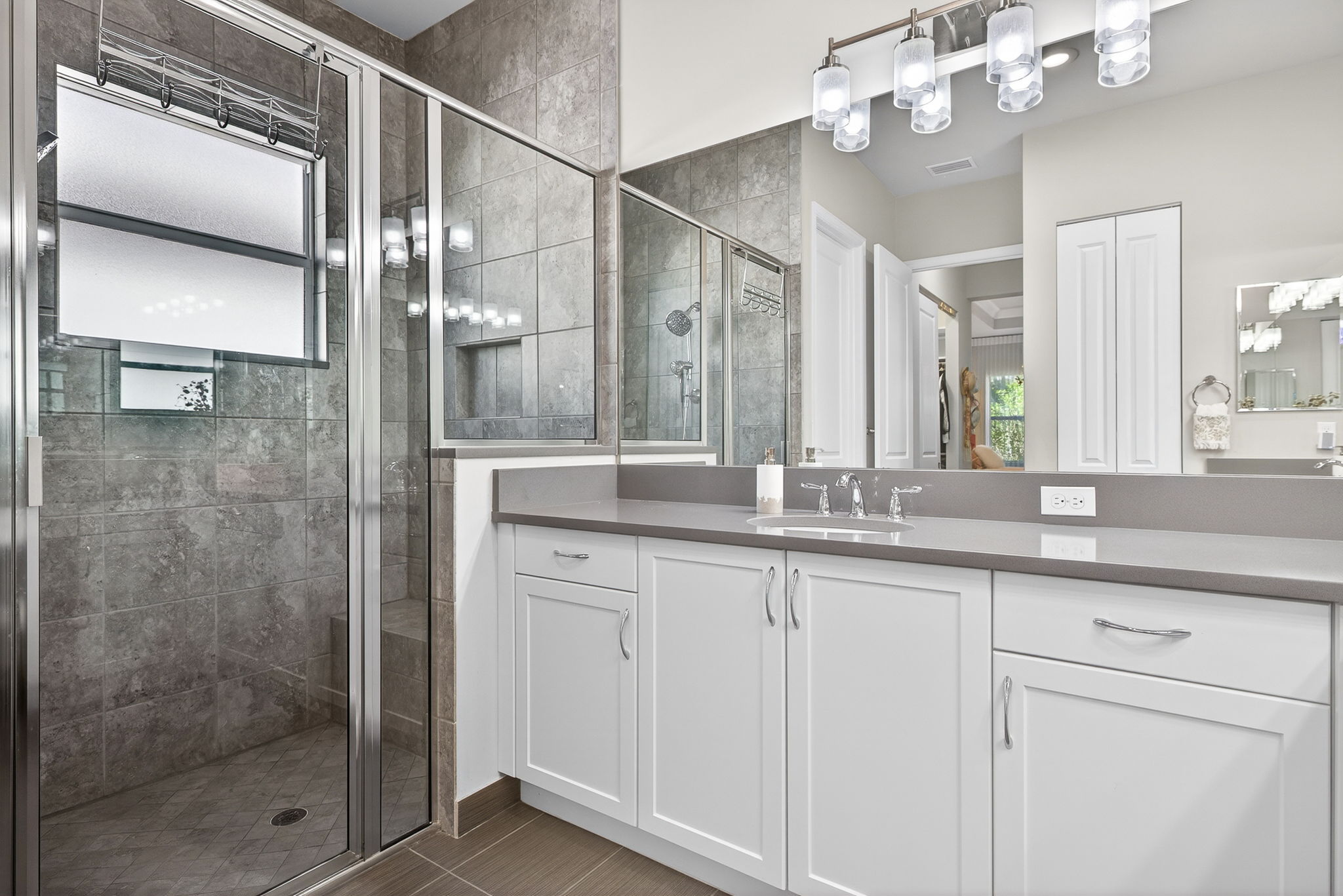 2nd sink, large shower with niche and bench, linen closet and toilet room complete this primary bath.