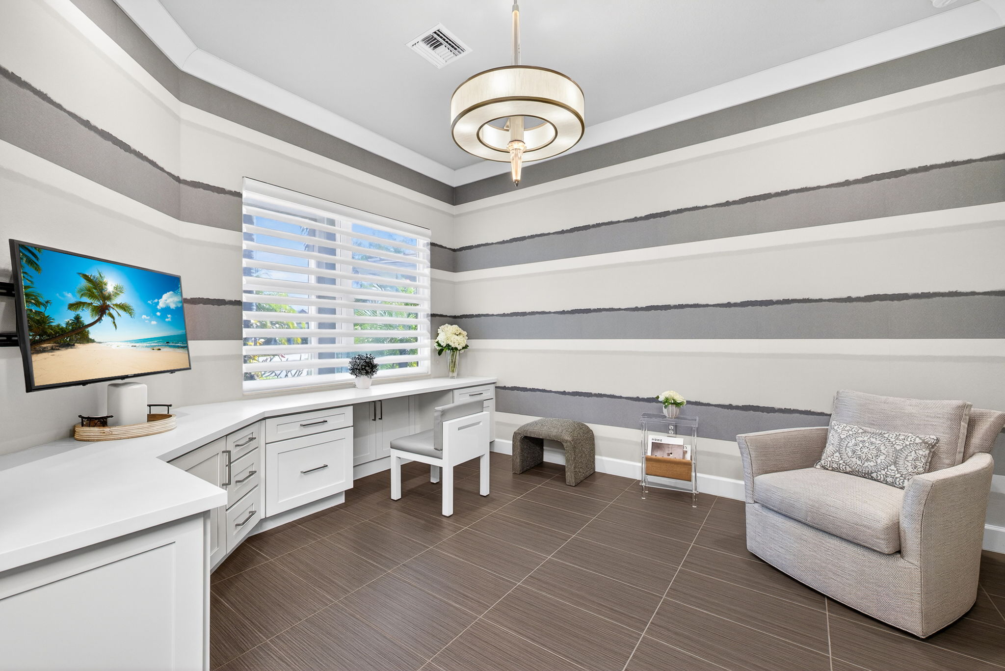 Sleek built-ins in the den provide easy storage and plenty of space to store your documents, family photos, and more! Hunter Douglas wide pleated remote control shades and custom wall covering complete the look here!