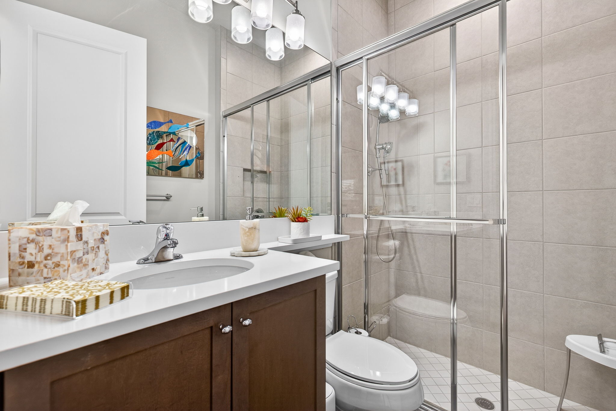 2nd full bath offers a walk-in shower, quartz countertop with banjo shelf, and floor to ceiling tile in shower.
