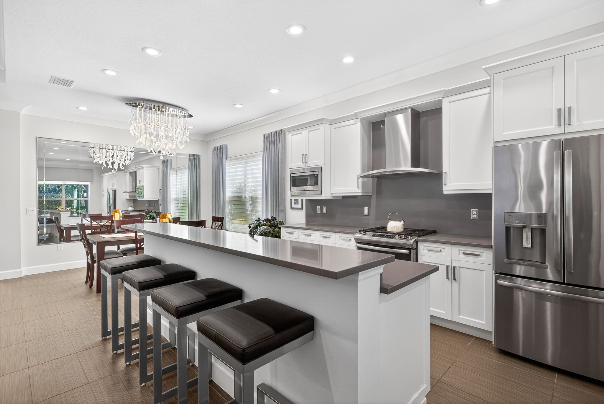 French door fridge, gas cooking, lots of overhead light, and the custom mirror in the dining area reflects a lot of light, too! Upgraded cabinets as well! Trash and recycle roll-outs present.