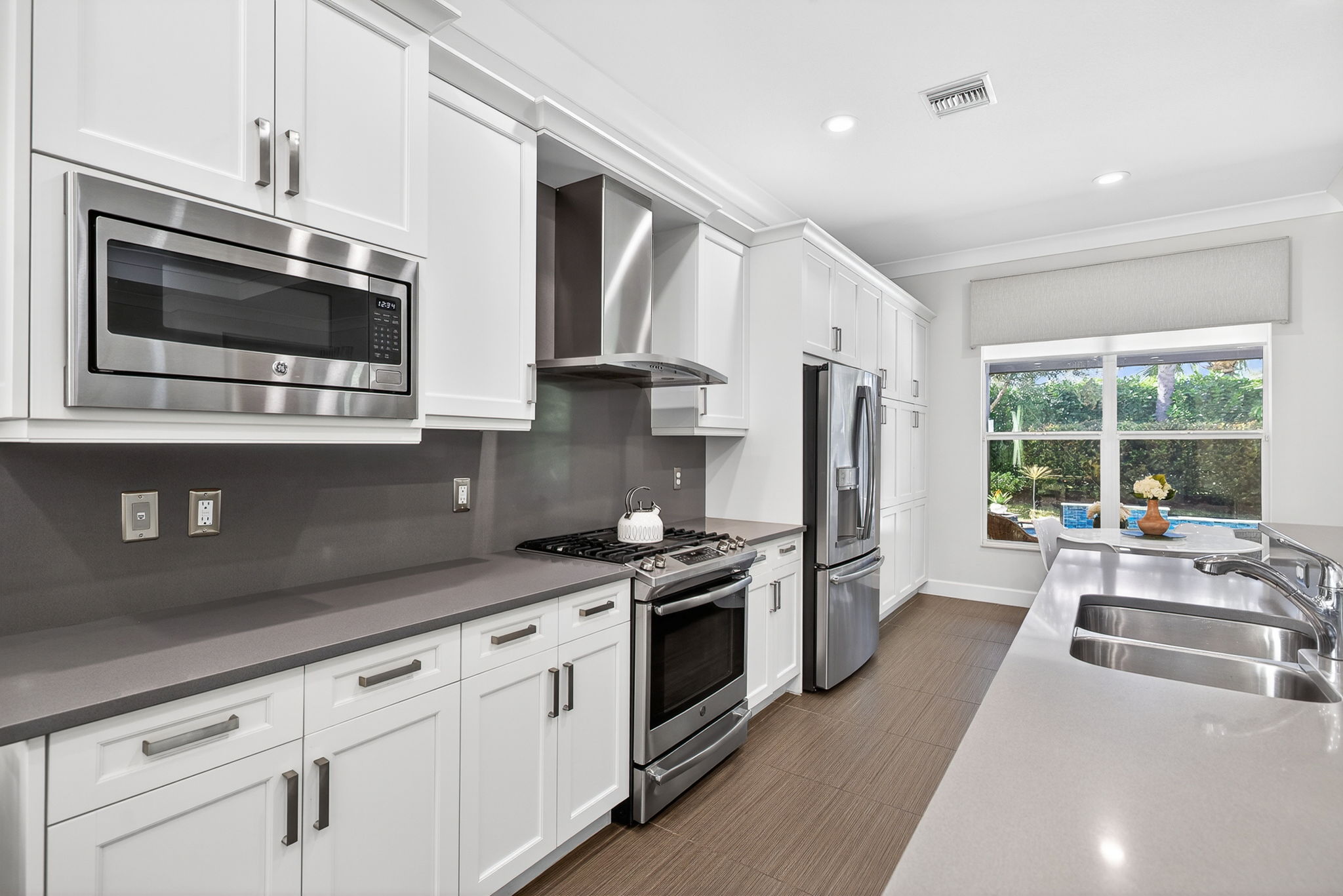 Breakfast nook overlooks the pool area! Built-in microwave, AMPLE white cabinetry, double sinks.