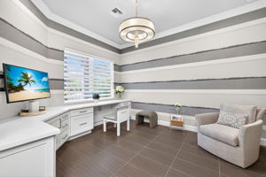 Sleek built-ins in the den provide easy storage and plenty of space to store your documents, family photos, and more! Hunter Douglas wide pleated remote control shades and custom wall covering complete the look here!