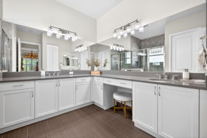 Floor to ceiling tile in shower, wall to wall mirrors, built-in vanity area, quartz counters, and 1st of 2 sinks.