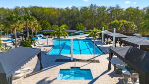 Community heated lap pool with 5 lanes, adjacent to the hot tub and flanked by cabanas.