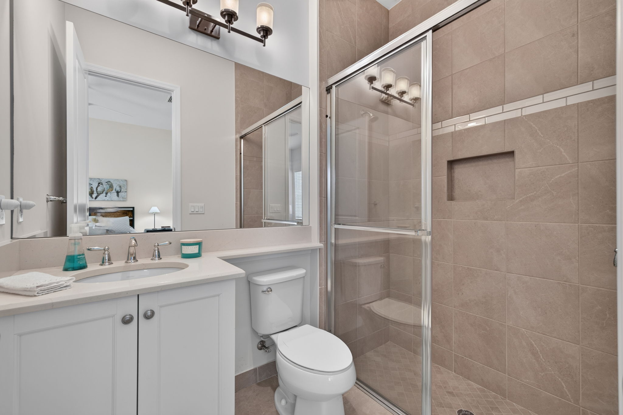 Ensuite bath to the 2nd bedroom, located to the left of the foyer.
