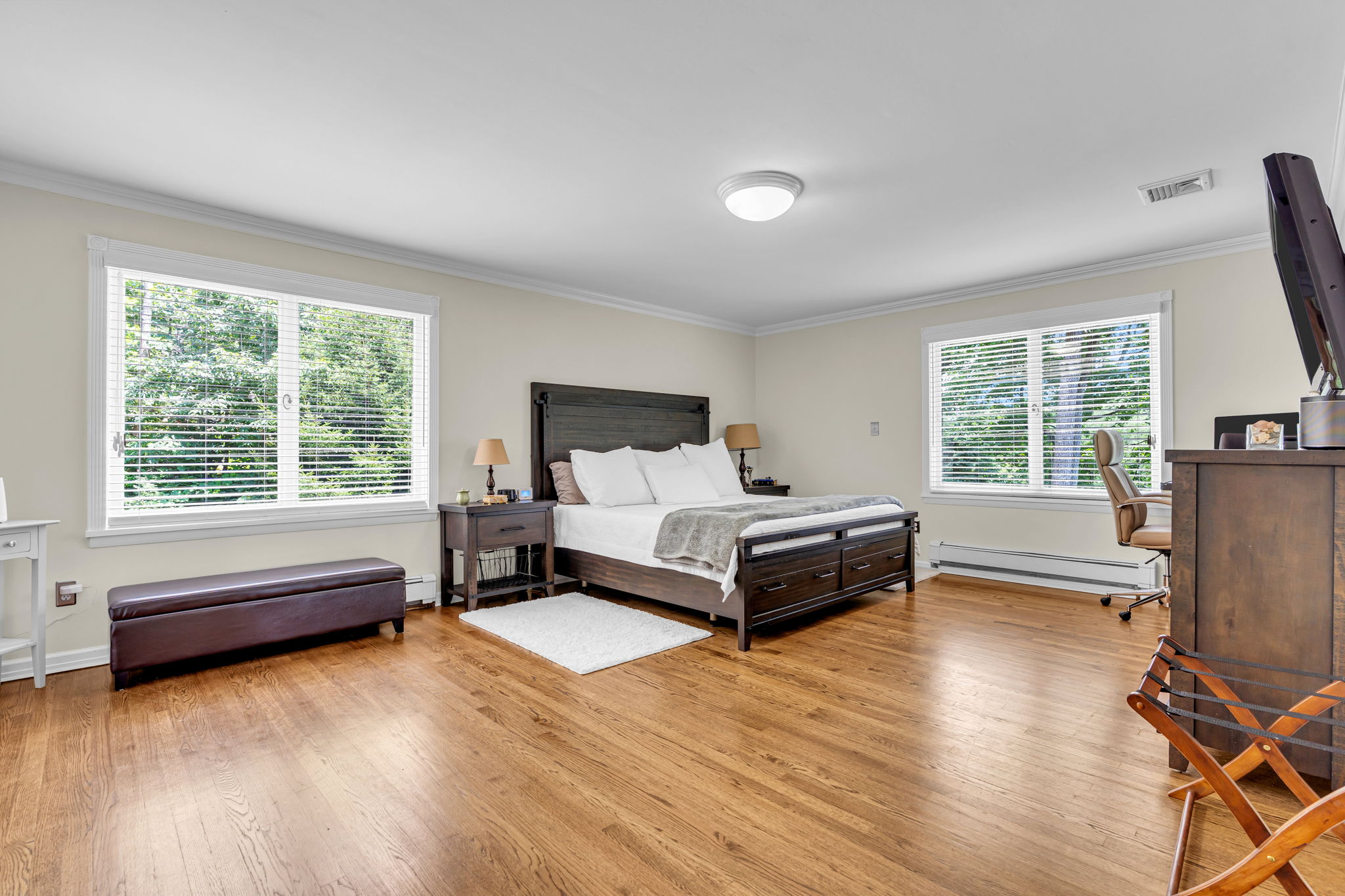 Spacious primary bedroom, hardwood flooring