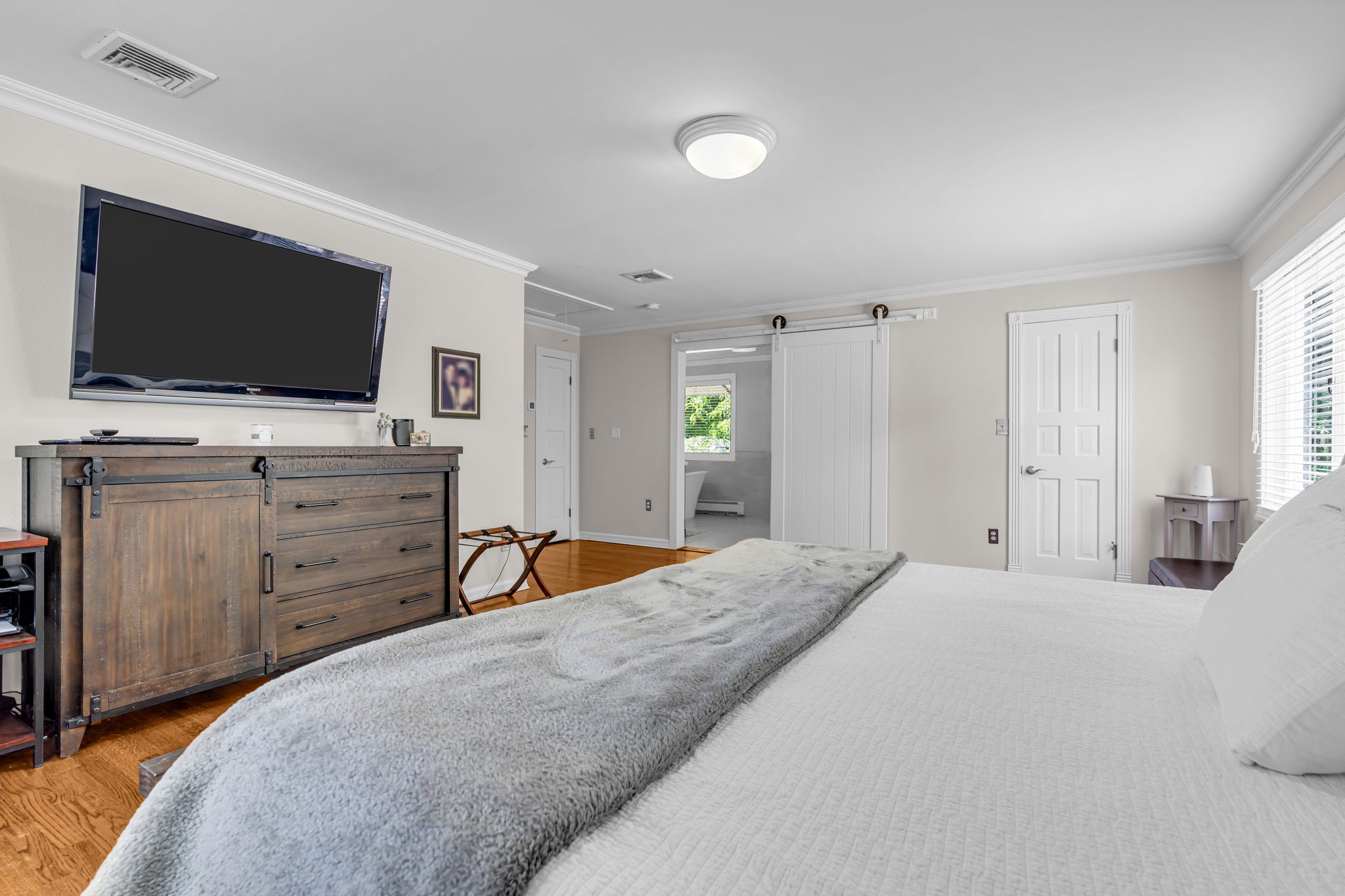 Primary ensuite bath with barn door entry, and walk-in wardrobe closet