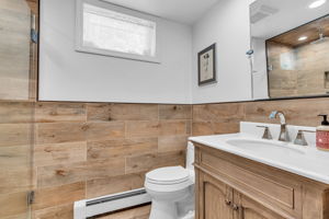 Lower level full bath with glass enclosed tiled surround shower