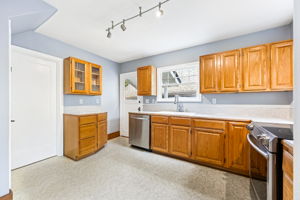Kitchen with plenty of floor space and stainless appliances.
