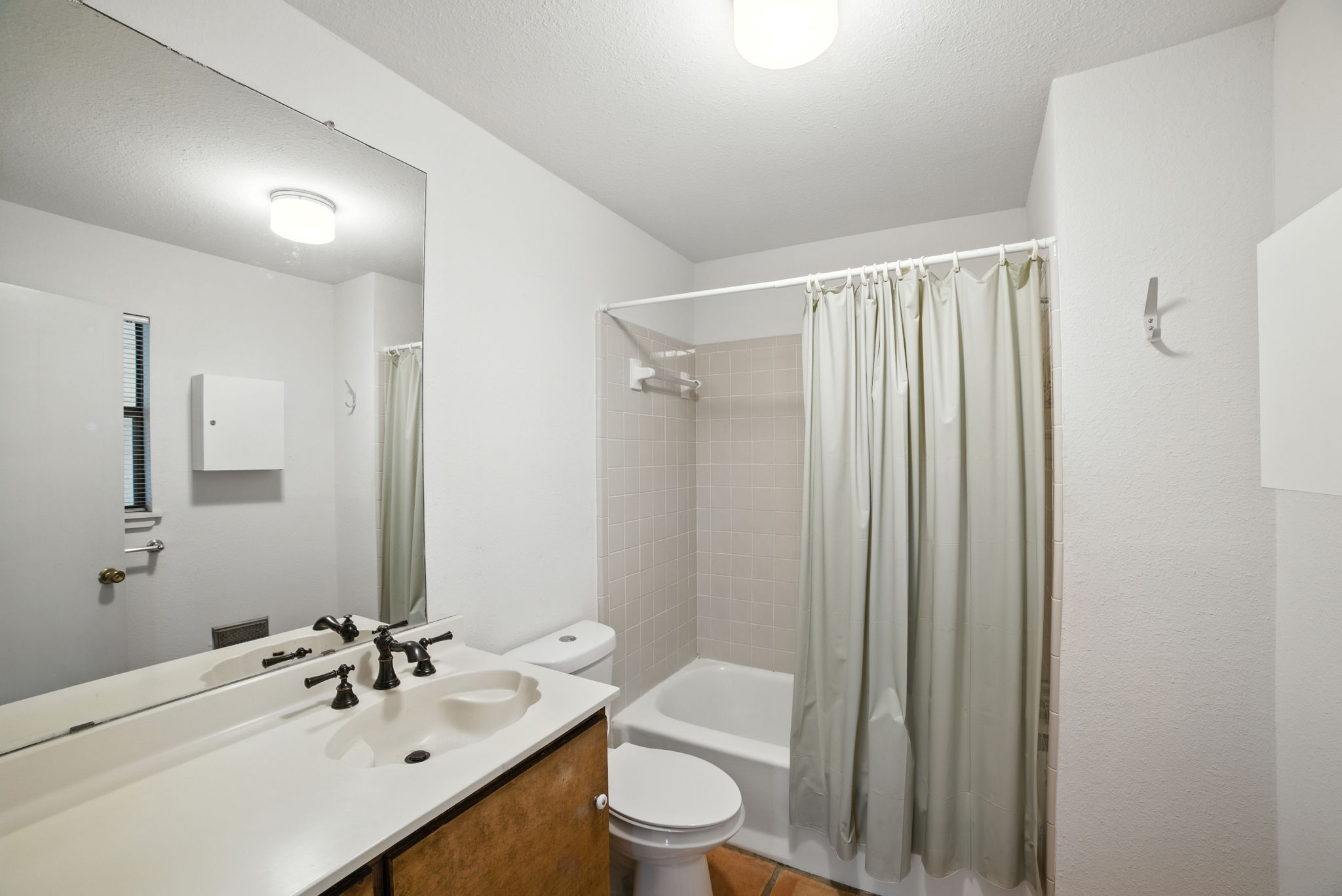 Located just off the back entrance, this full bathroom offers convenience for both residents and guests. With a tub-shower combo, clean finishes, and easy access from the living areas and patio, it’s designed to handle everyday needs with practicality and ease.