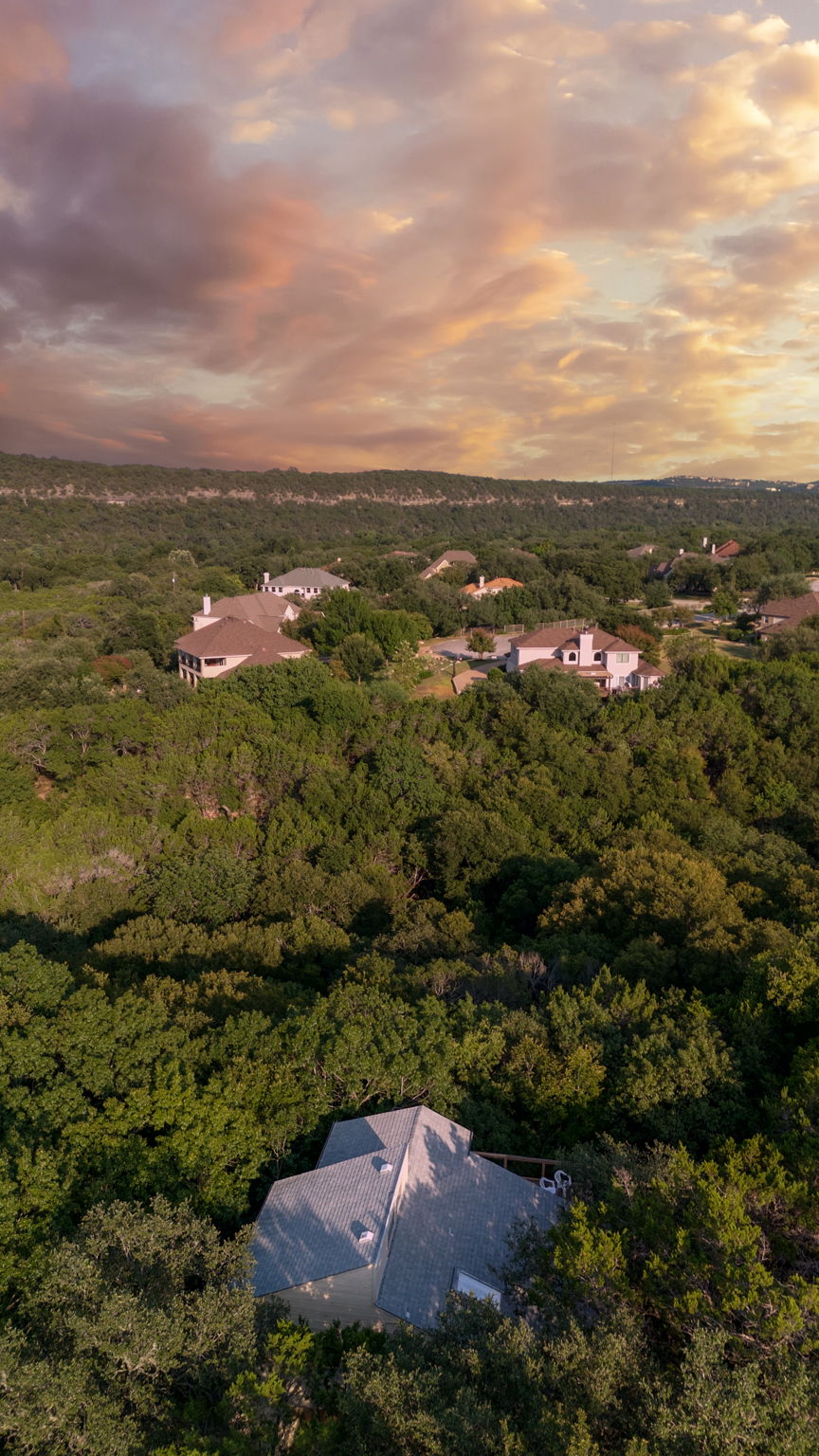 Breathtaking Hill Country sunsets frame this private retreat, tucked deep into a canopy of mature trees. The home sits quietly back from the street, offering unmatched privacy while still being just minutes from Lake Austin and in the highly acclaimed Eanes ISD.
