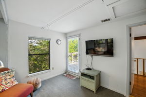 From this upstairs bedroom, step directly out to the expansive back patio and take in the elevated views. The combination of indoor comfort and outdoor access makes this room a standout feature, blending functionality with the home’s treehouse-like setting in Eanes ISD.