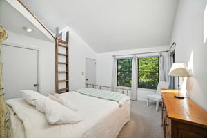 Abundant natural light pours in through multiple windows, creating a bright and inviting atmosphere in the primary bedroom. The open layout highlights the room’s generous size while connecting seamlessly to the ensuite bath and walk-in closet.