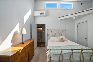 Clerestory windows bring in additional light while maintaining privacy, giving the primary bedroom a serene and airy feel. With both functional storage and a tranquil loft retreat, this space offers the perfect balance of practicality and relaxation.