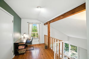 At the top of the stairs, a bright loft space offers a flexible area that can be used as a home office, reading nook, or creative studio. With treetop views and natural light, it captures the home’s treehouse charm while providing everyday functionality.