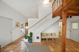 The entryway welcomes you with soaring ceilings, warm tile floors, and an open staircase that sets the tone for the home’s spacious design. Natural light and rustic wood accents highlight the inviting character, offering a true blend of comfort and Austin charm.
