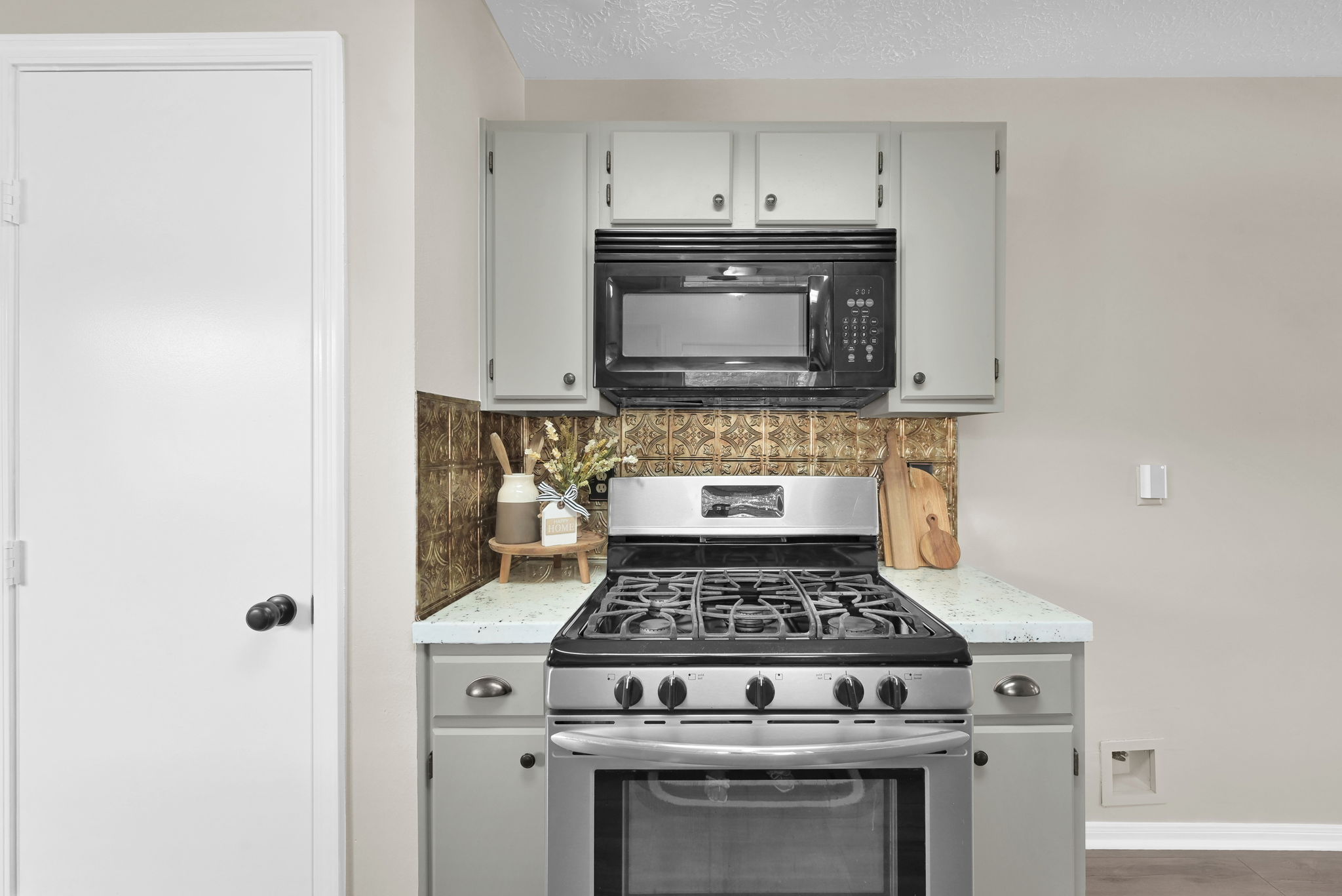 This home comes with a Stainless steel GAS RANGE and microwave. The door on the left leads to the pantry.