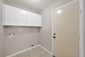 UTILITY ROOM w/ added cabinetry (always nice to have). Door on the right leads to the garage (which has storage cabinets, as well).