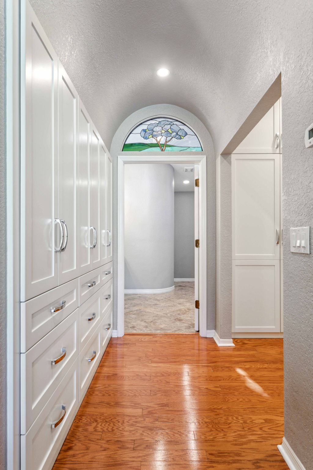 Gorgeous custom built-in closets with barrel ceiling and stained glass window
