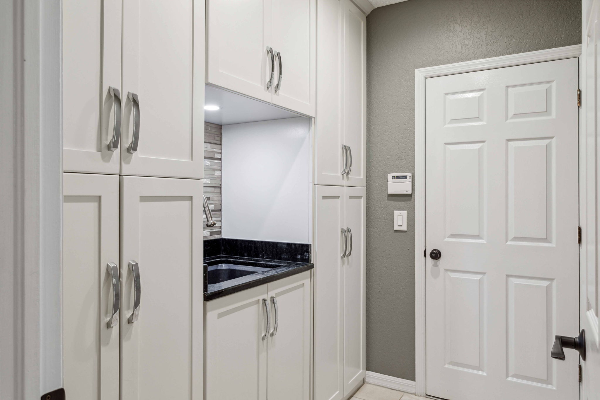 Utility Room with sink and generous amount of custom cabinetry